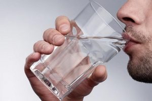 мужчина пьет воду из стакана