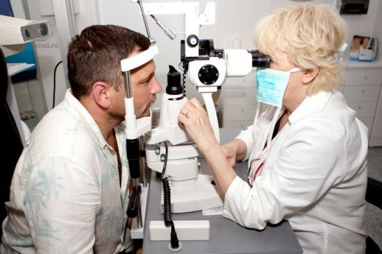 Офтальмолог осматривает пациента